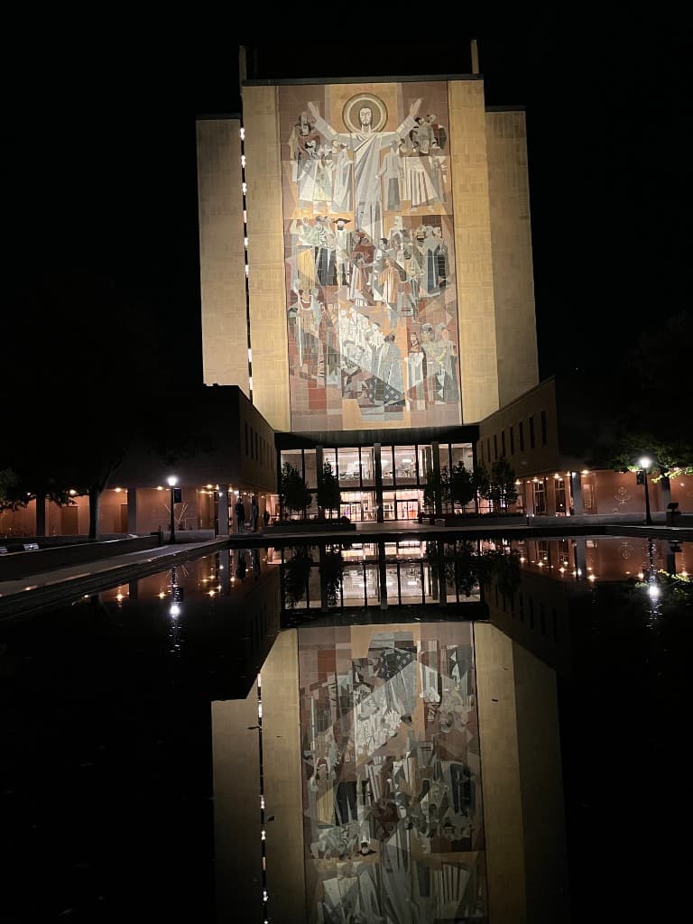 Hesburgh Library at the University of Notre Dame at night, reflected in the campus pool