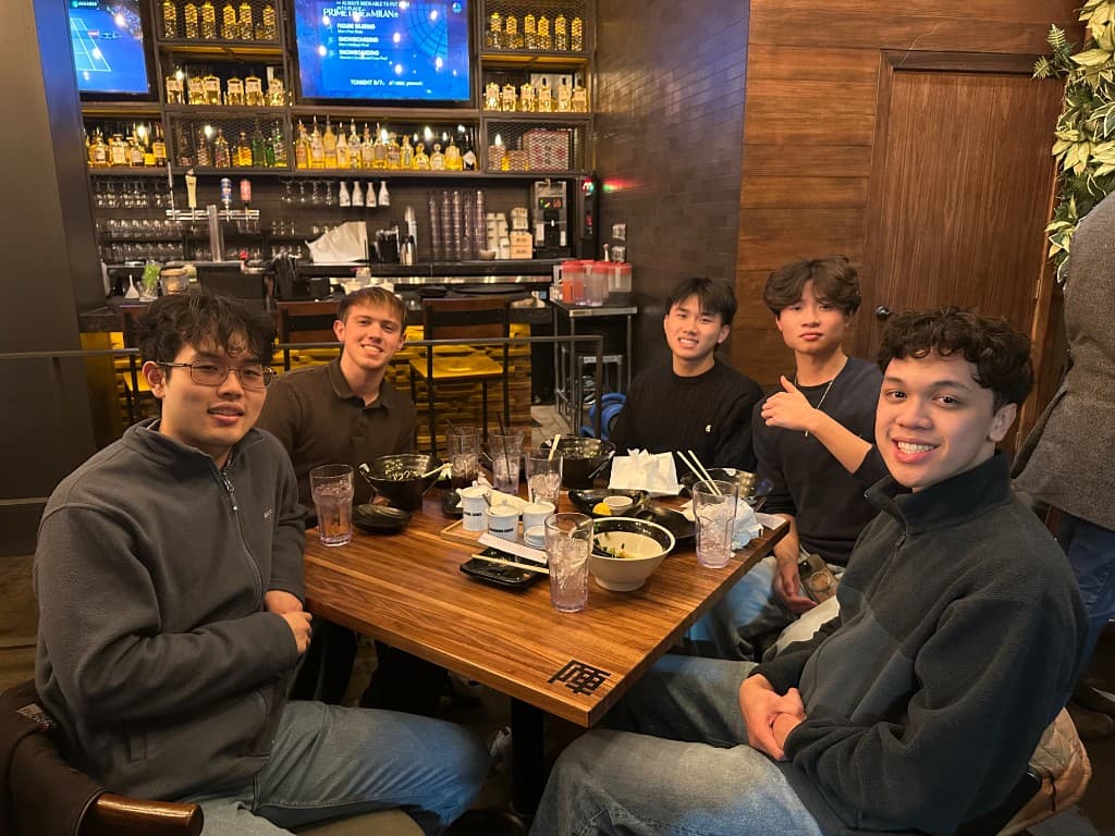 Caden and friends sharing a meal at a ramen restaurant